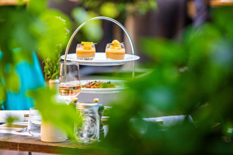 Gedeckter Tisch mit Etagere im Hofgarten des Restaurants alto